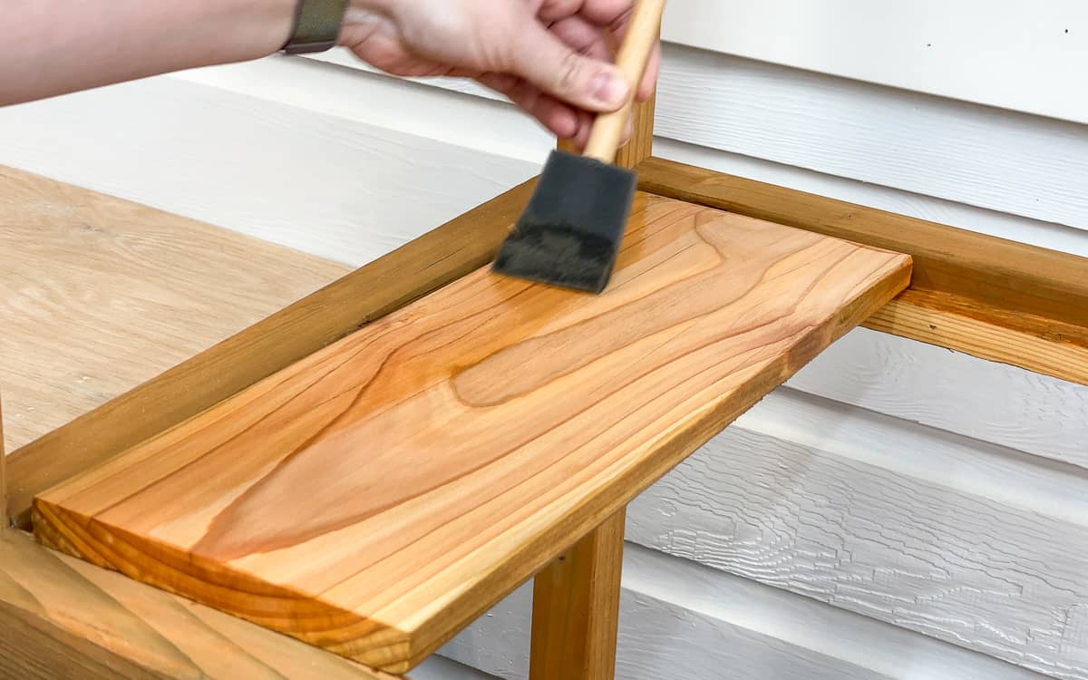 applying spar urethane to the DIY greenhouse shelf slats