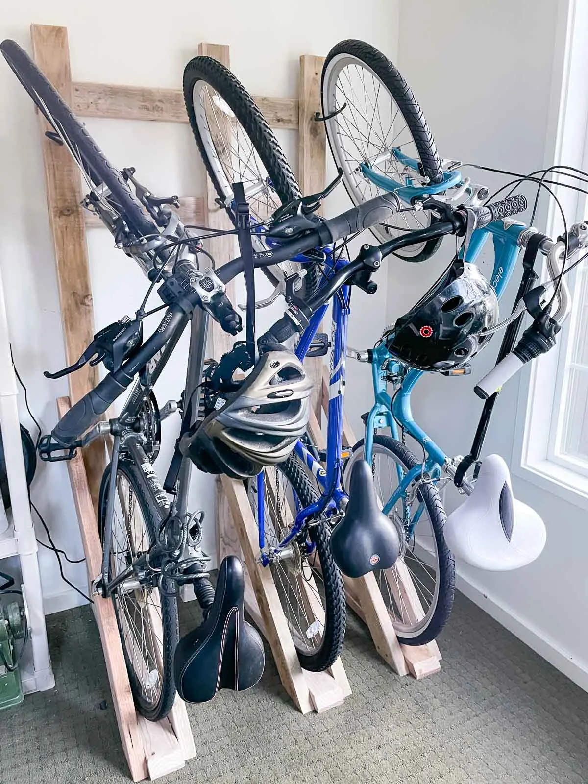 DIY vertical bike rack with three bicycles on wall