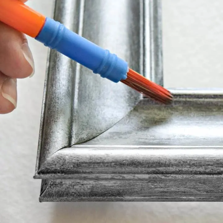 painting a picture frame with a brush