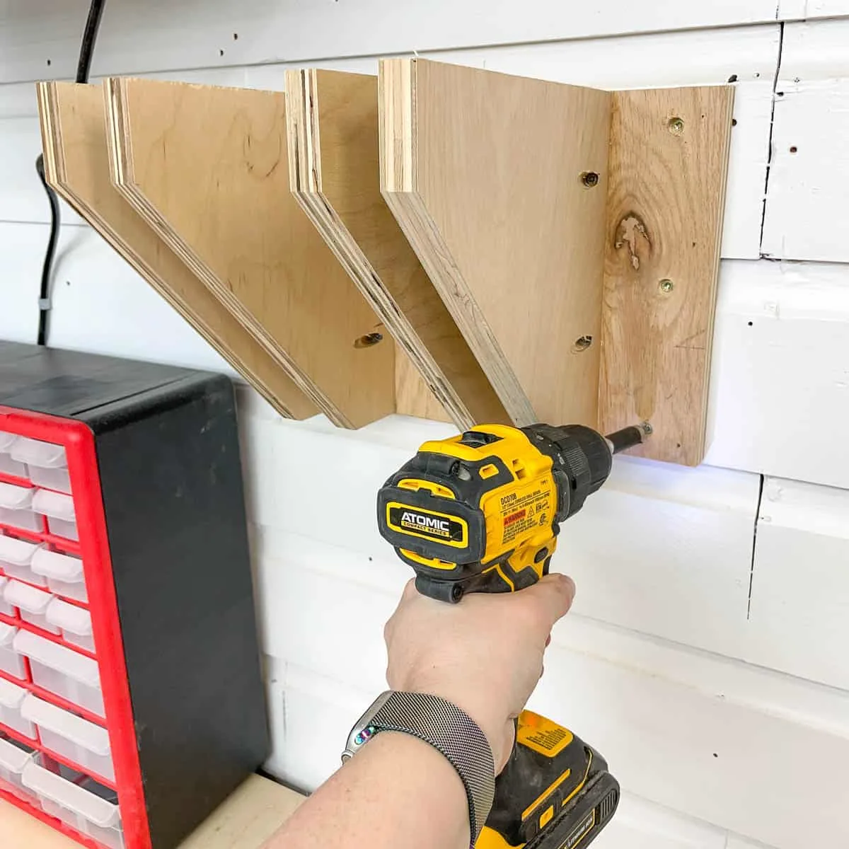 screwing DIY clamp rack to the wall with a cordless drill