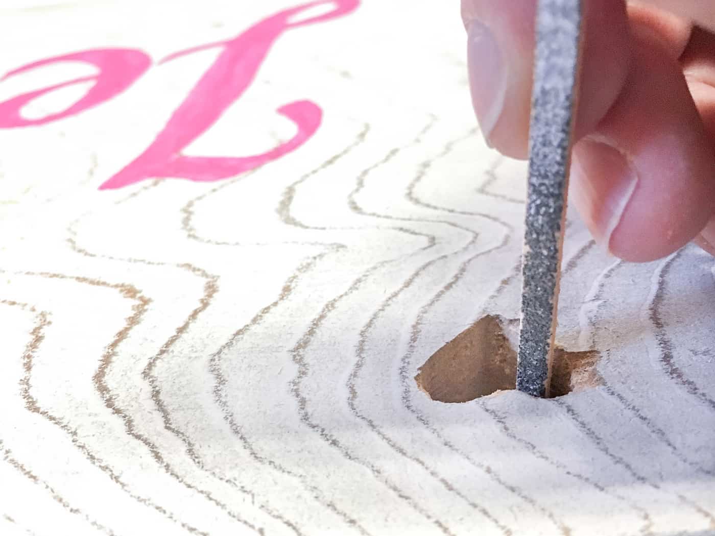 using sanding twig to clean up the inside of a chiseled hole