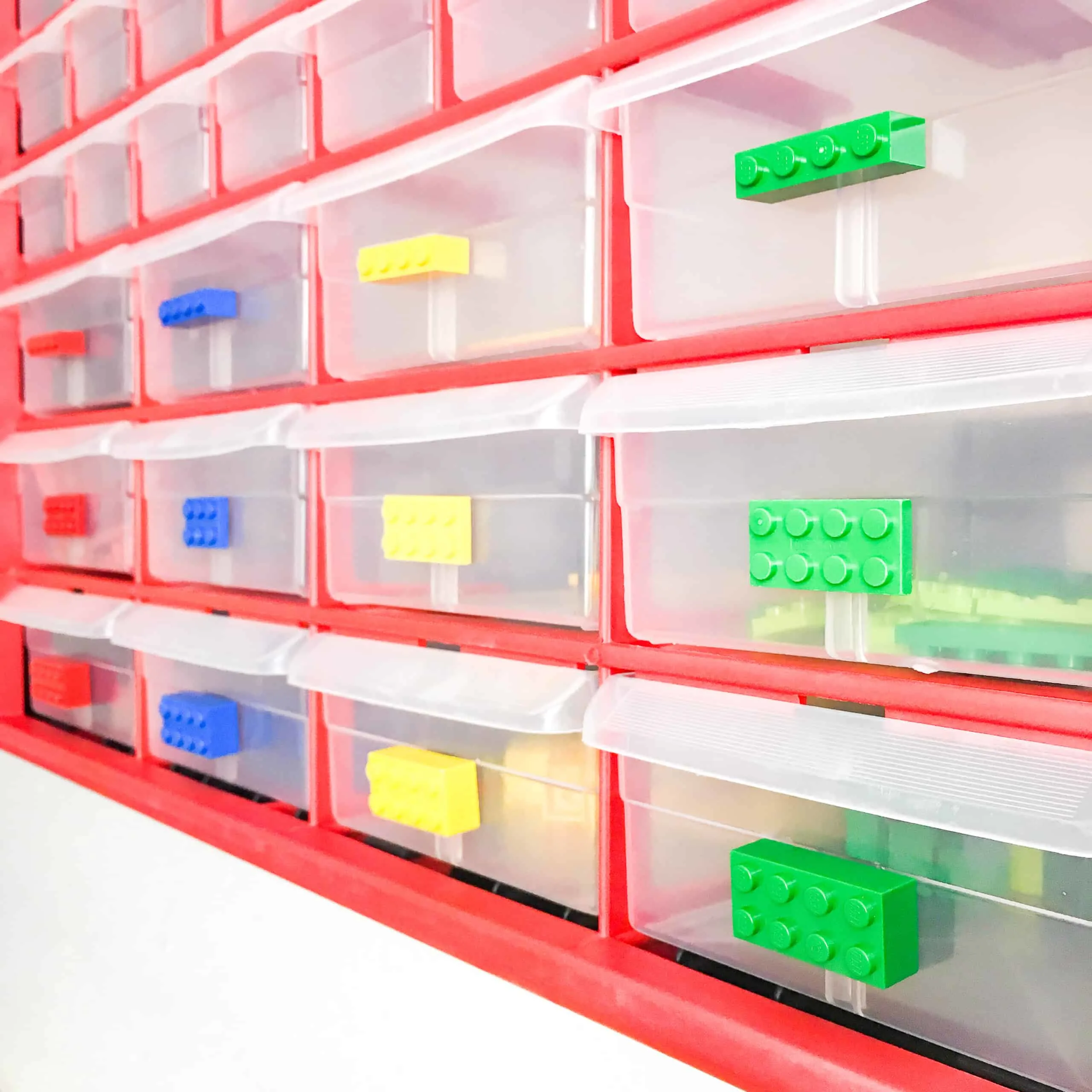 small parts bins with a Lego piece attached to each drawer