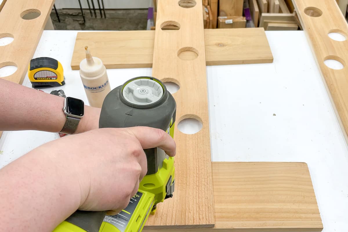 assembling base of DIY strawberry tower with a brad nailer