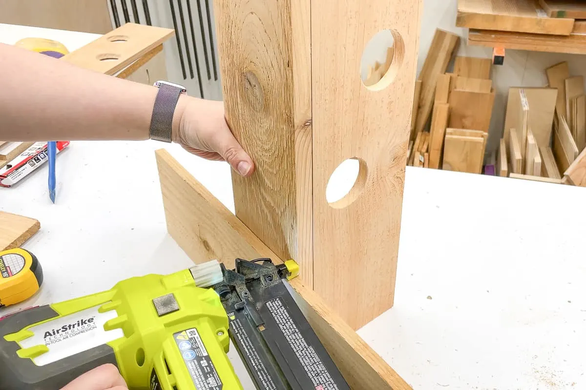 attaching sides of strawberry tower with a brad nailer