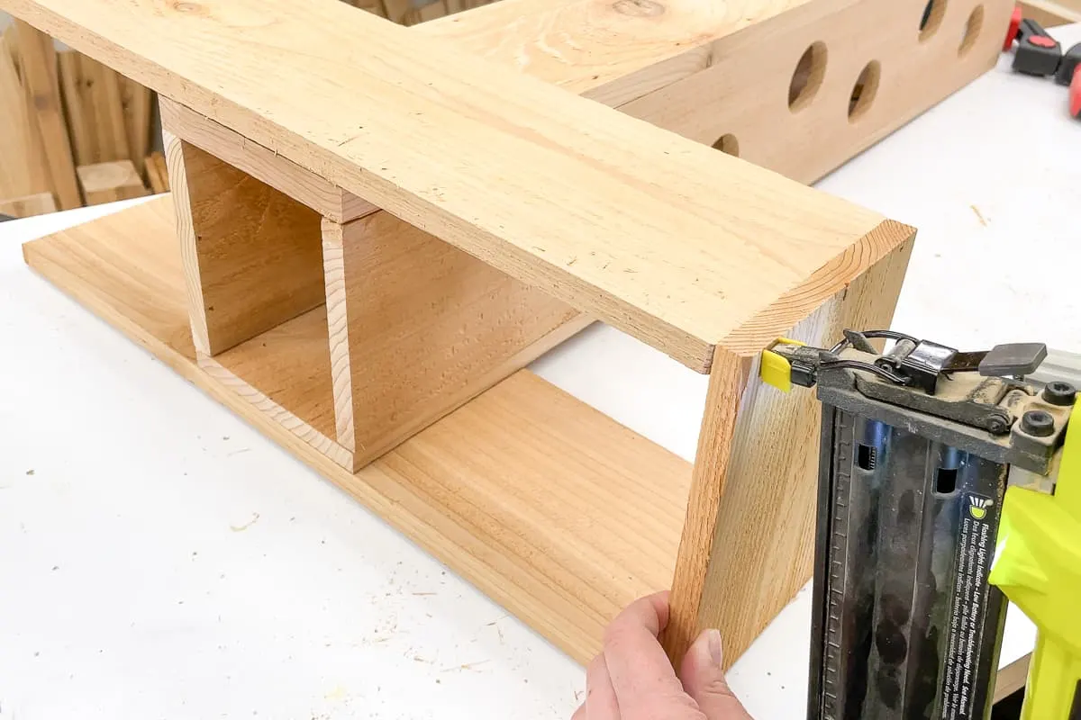 attaching ends of the strawberry planter base with a brad nailer