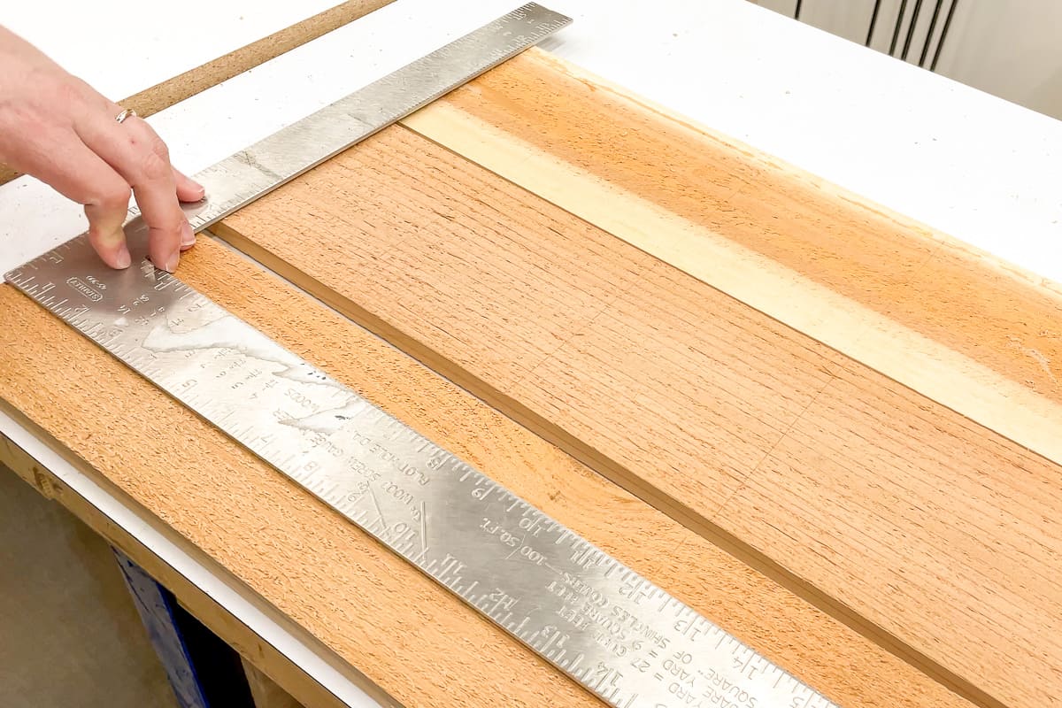 drawing a grid for strawberry plant placement with a metal ruler