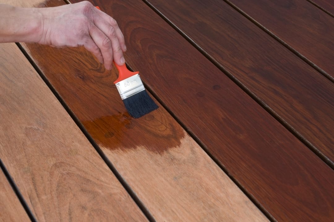 applying new deck stain over old stain