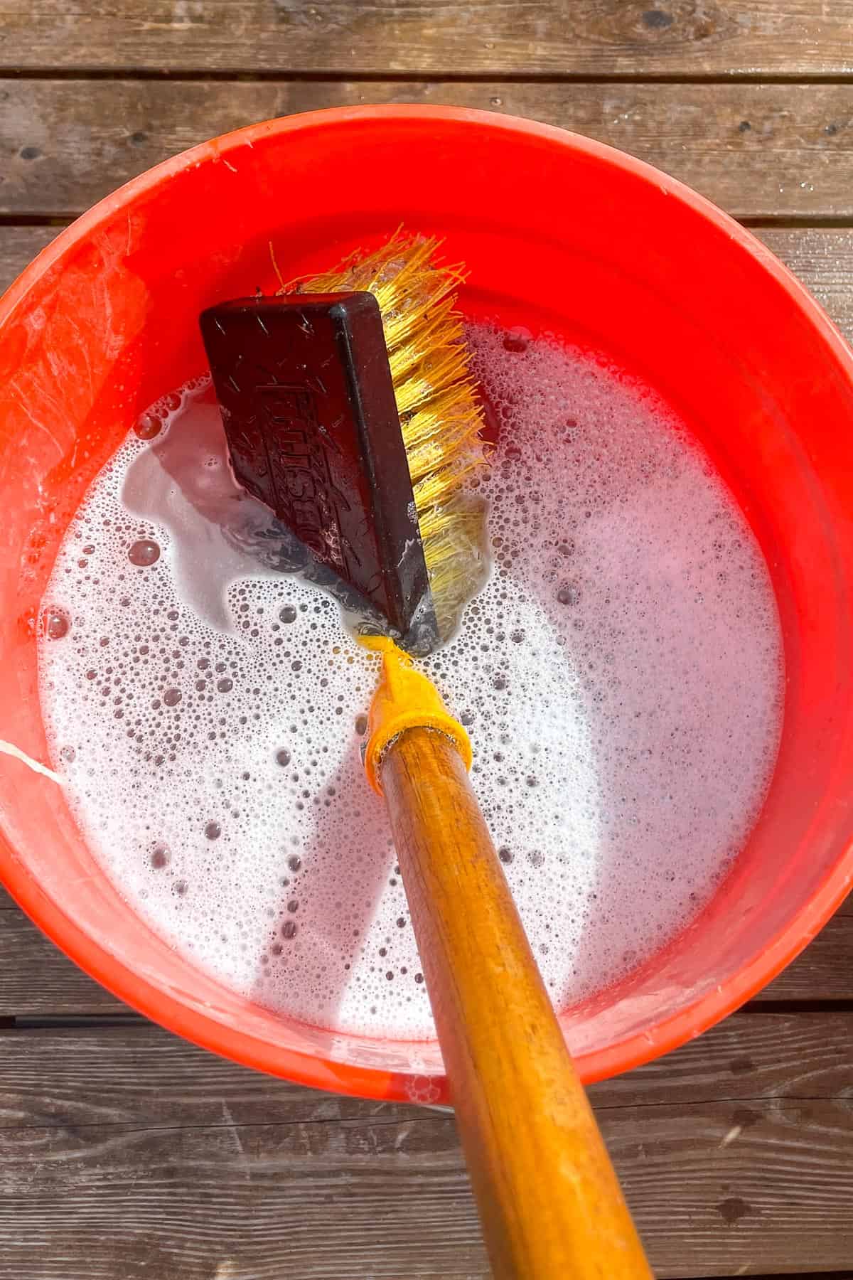 scrub brush in deck cleaner bucket