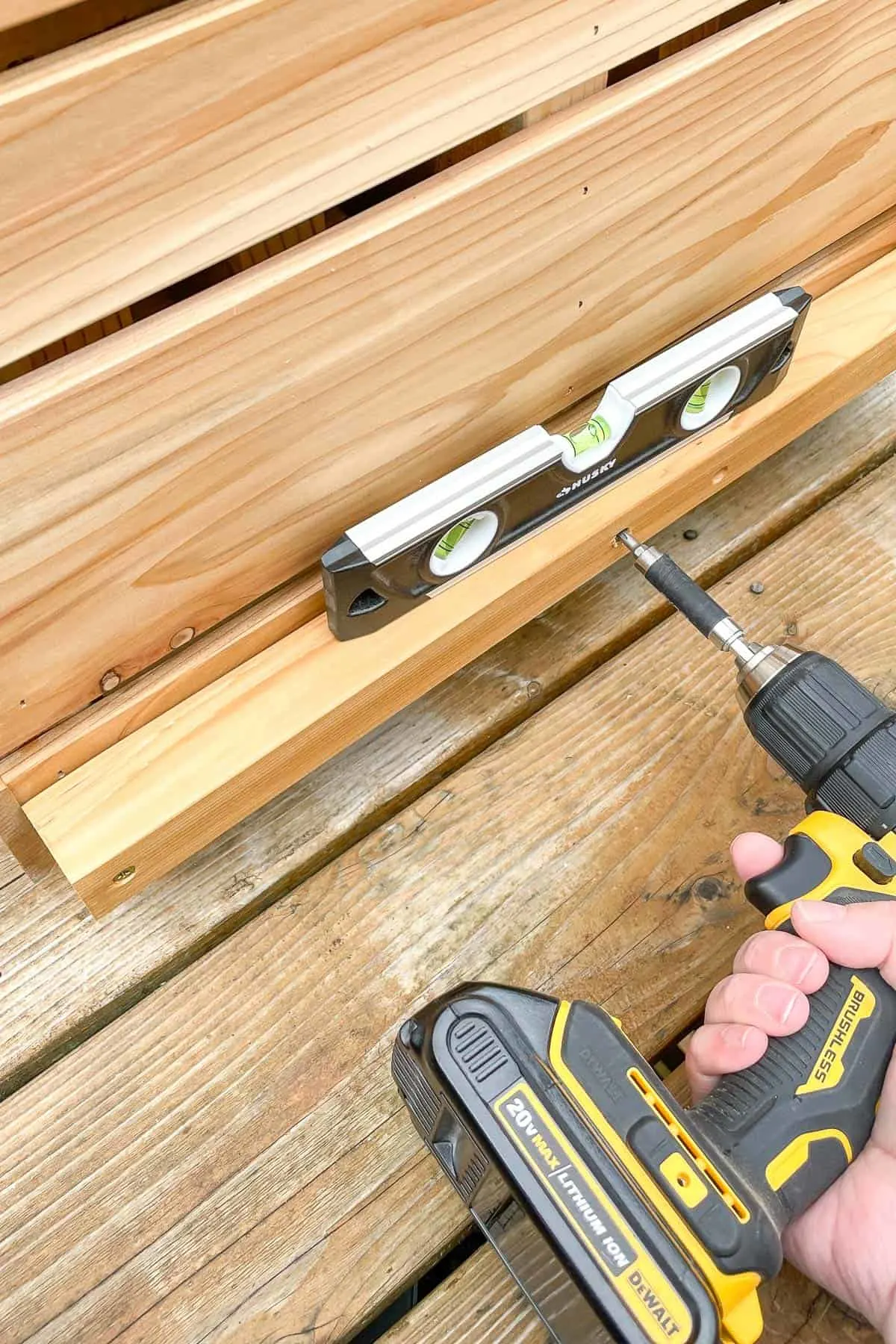 attaching the bottom plant shelf support with a drill and a level