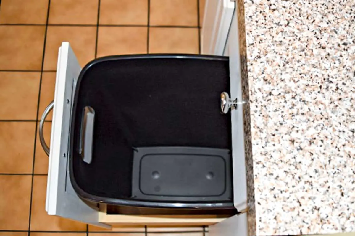 inserting trash can into cabinet