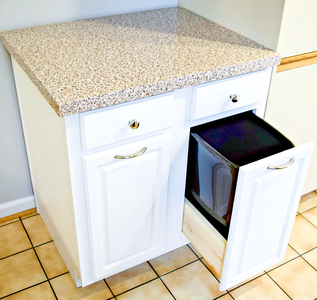 used kitchen cabinet converted to a trash can cabinet