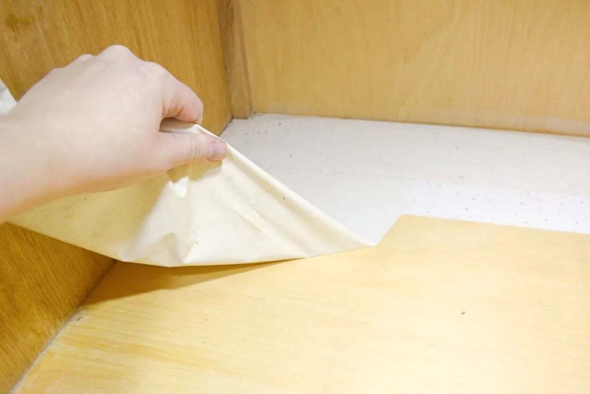 removing old contact paper from the bottom of used kitchen cabinets