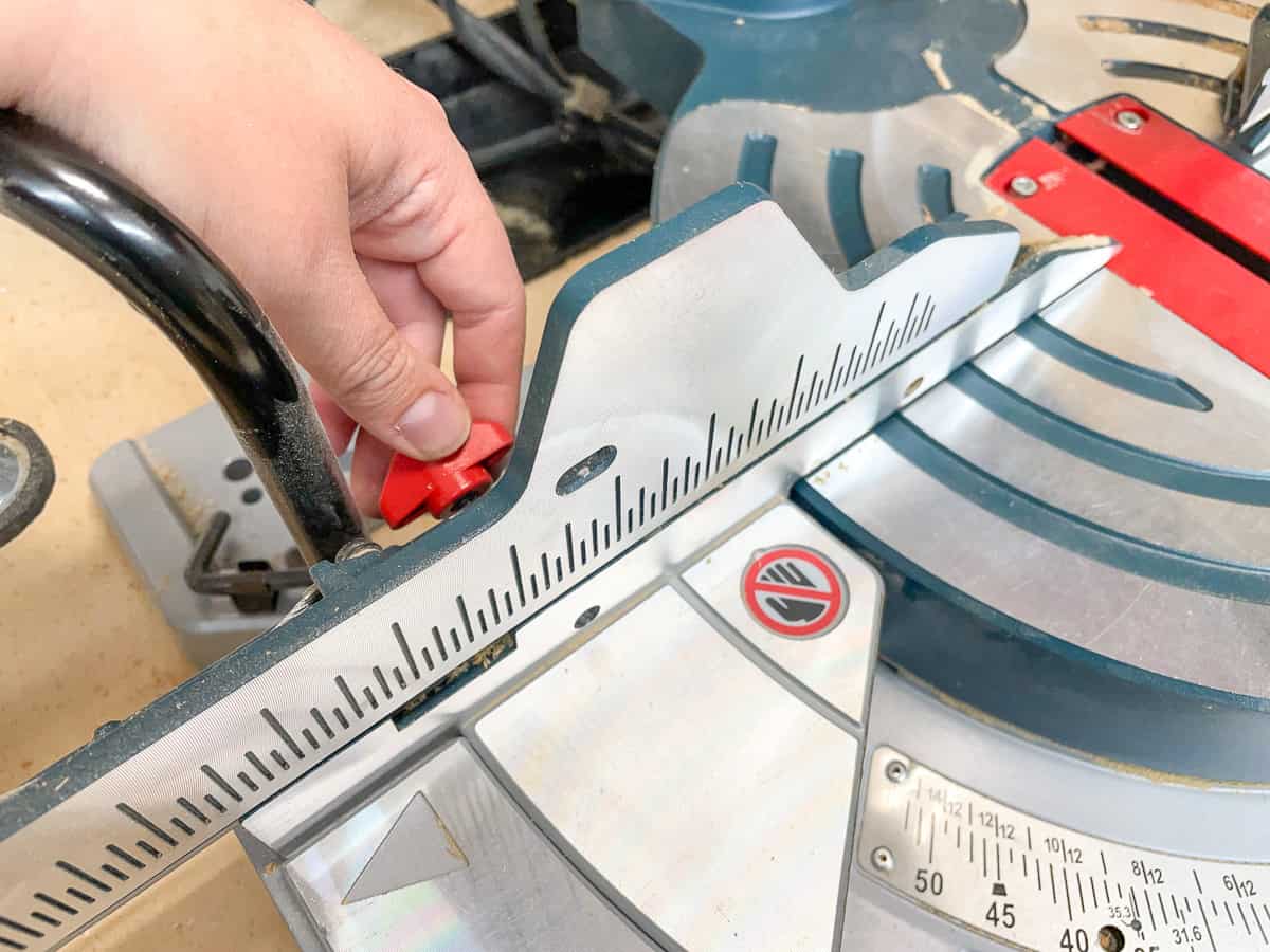 knob on the back of the miter saw fence to widen the gap for a bevel cut