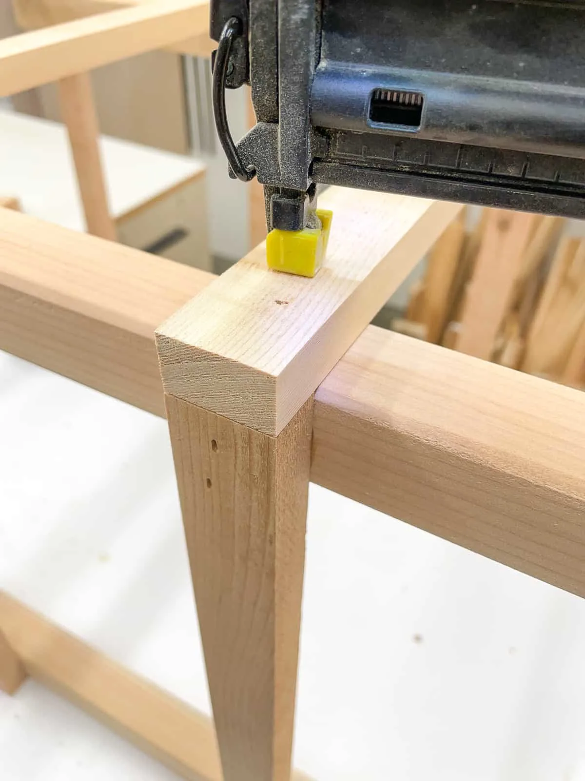 attaching slats to a wooden tomato cage with a brad nailer