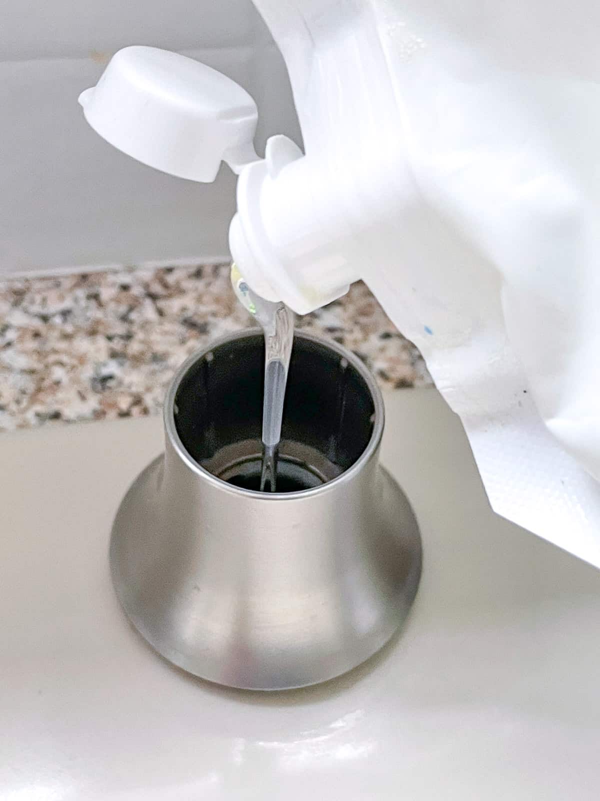 filling kitchen sink soap dispenser from above