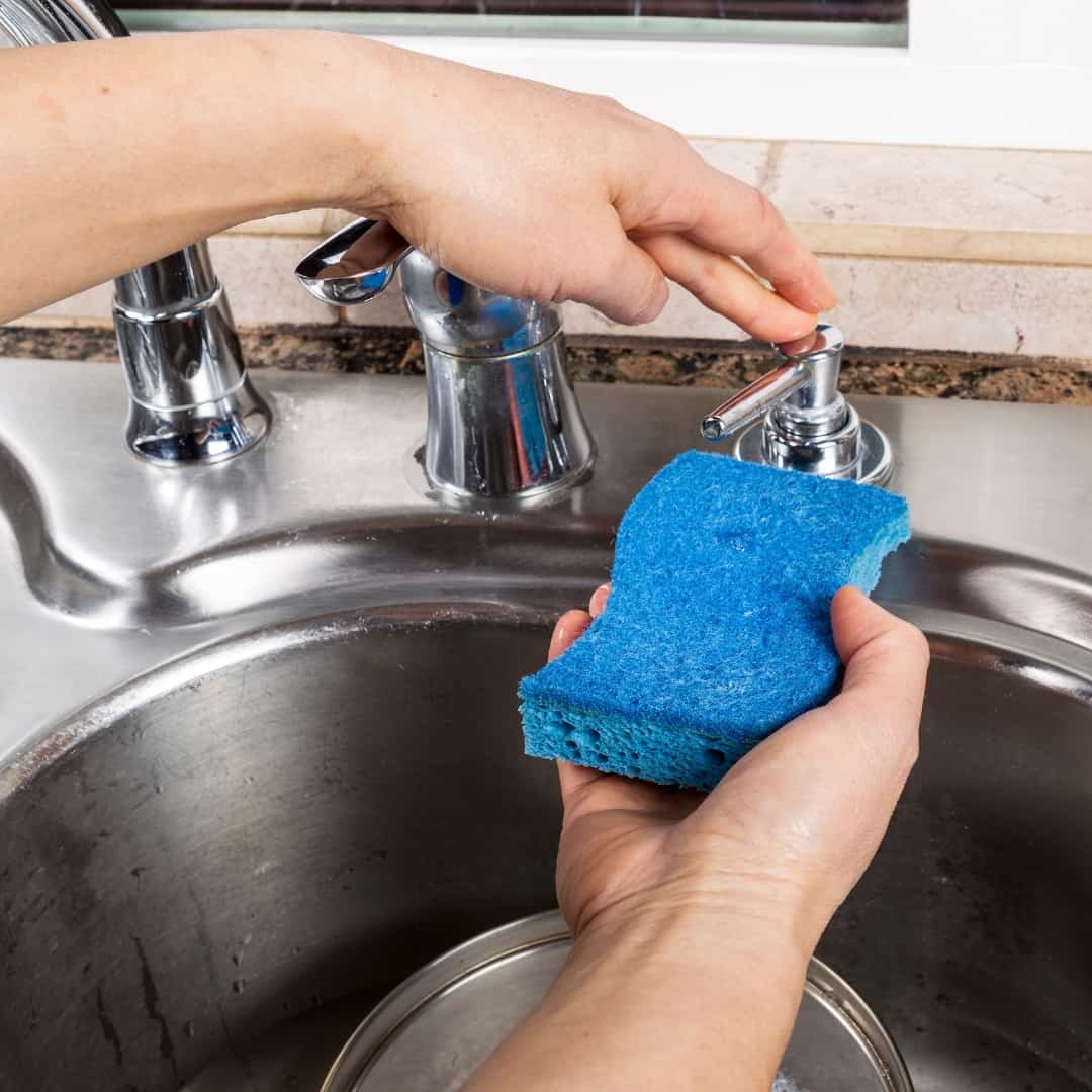 using a kitchen sink soap dispenser for dish soap on a sponge