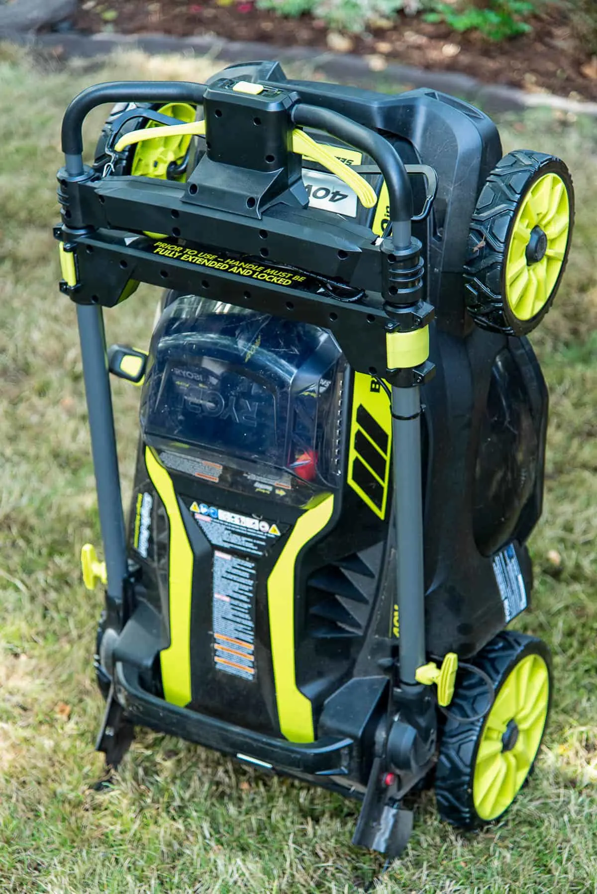 ryobi self propelled electric lawn mower folded up and ready for storage