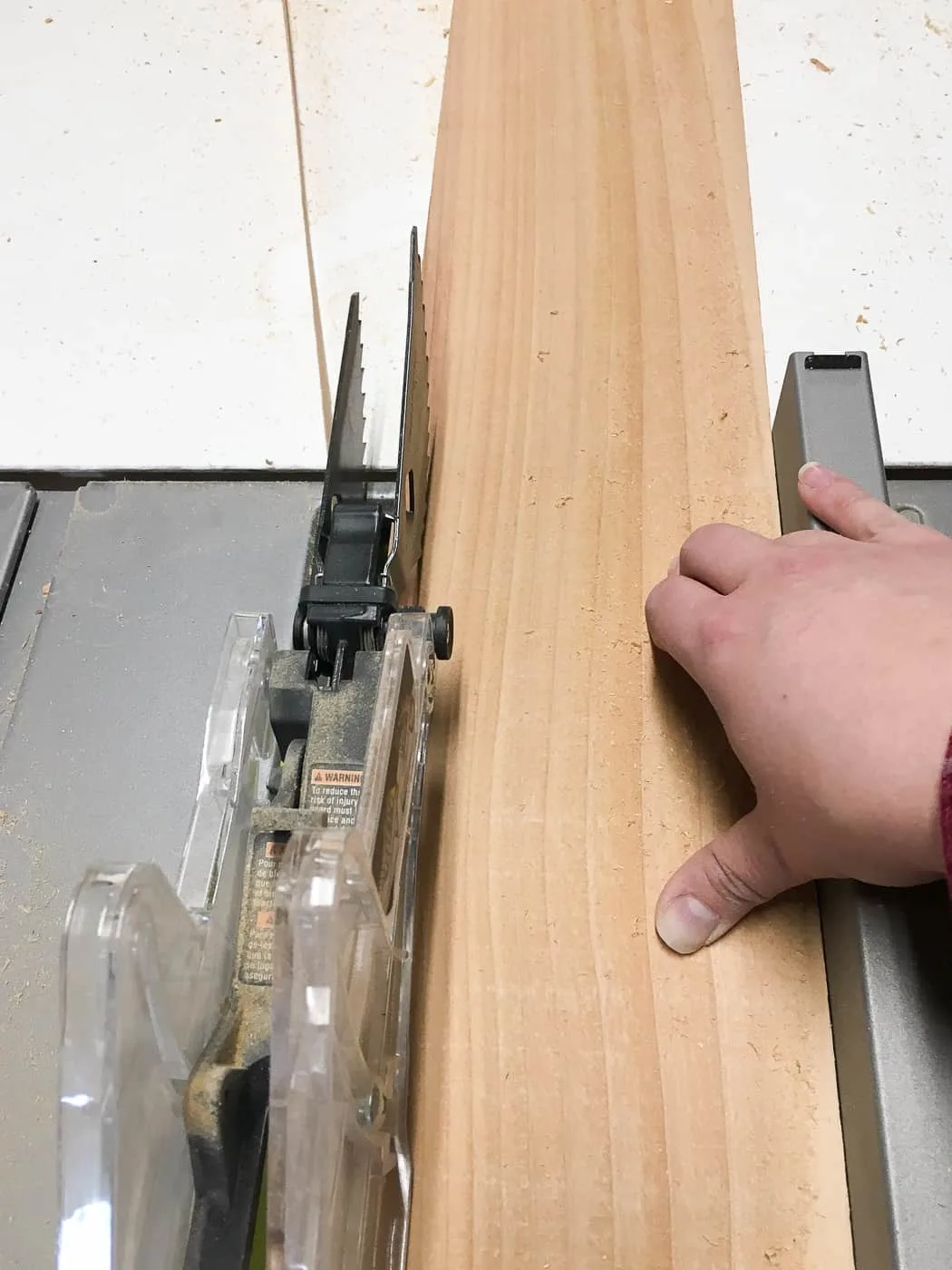 cutting off rough edge of a cedar fence picket on the table saw