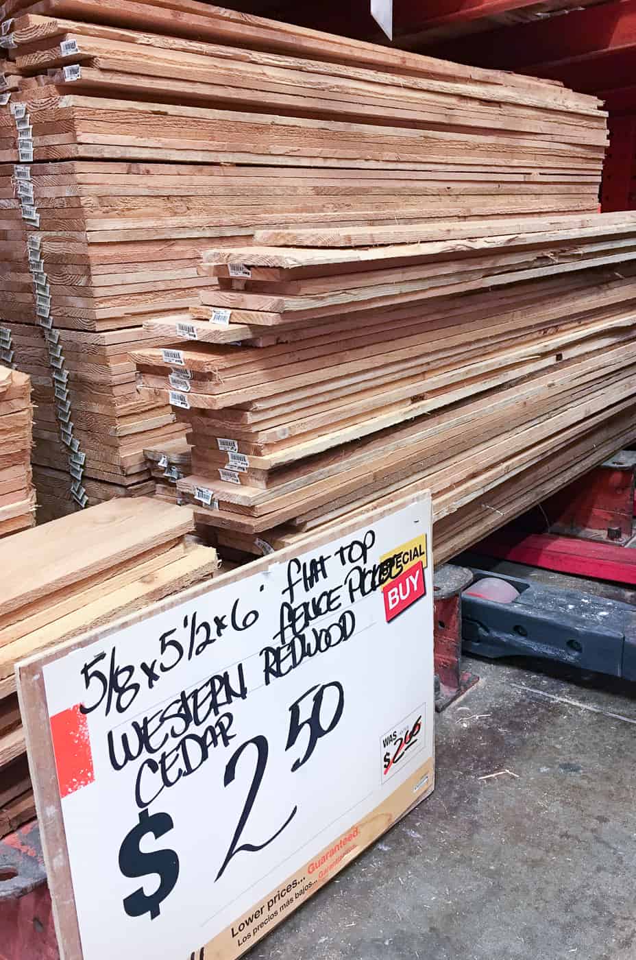 cedar fence pickets in a pile at Home Depot with price sign