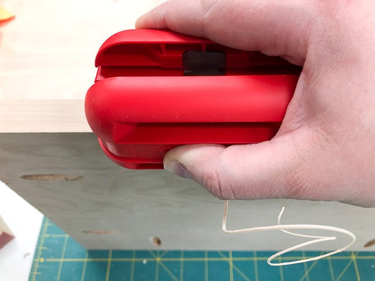 using an edge banding trimmer on a plywood shelf