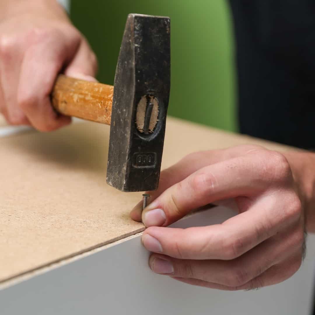 attaching cabinet back panel with a hammer and panel nails