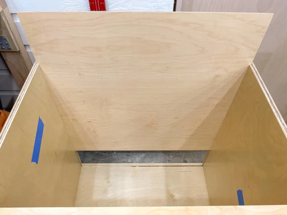 sliding the back panel into the cabinet box with the grooves cut in the sides and bottom
