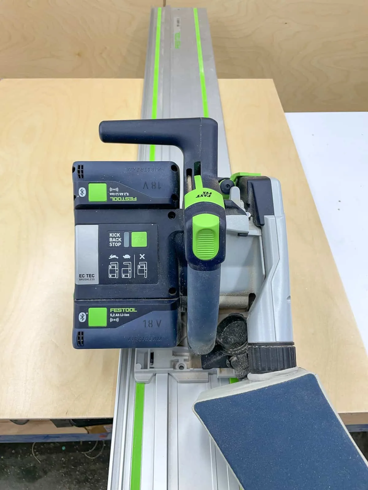 Festool track saw with track on plywood sheet before cutting cabinet box pieces