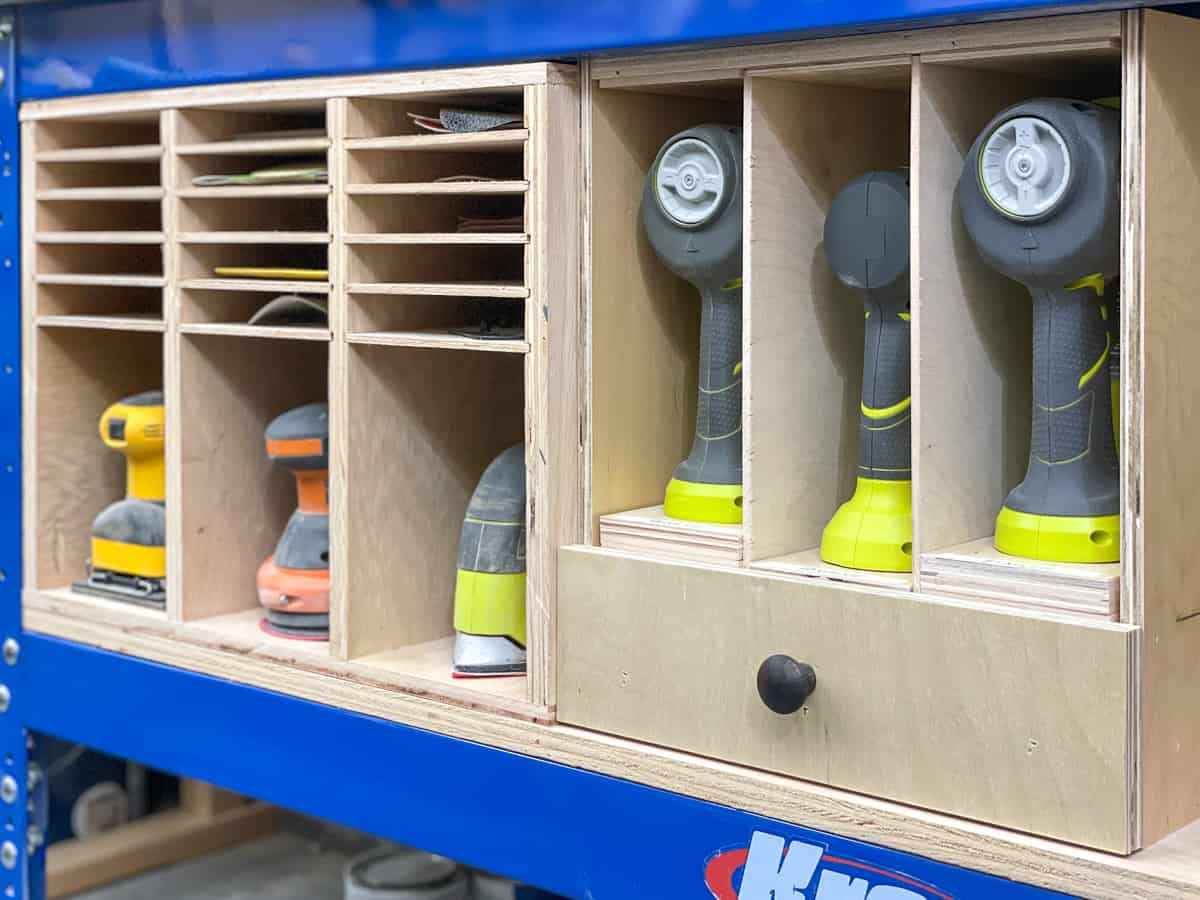 nail gun organizer next to sander and sandpaper storage under workbench