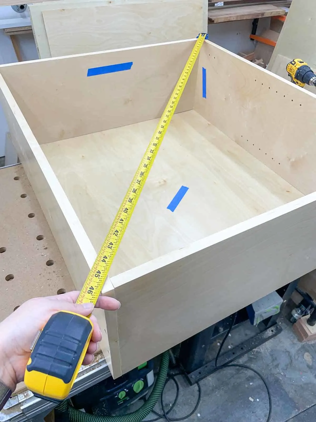 measuring the diagonal of a wall cabinet to check for square