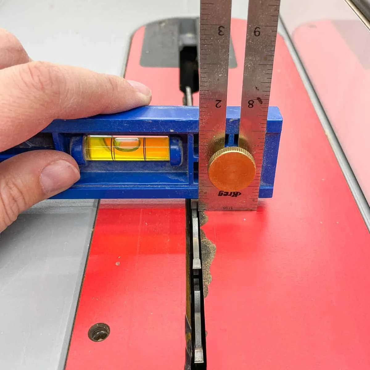 measuring the height of the blade at the table saw with a combination square