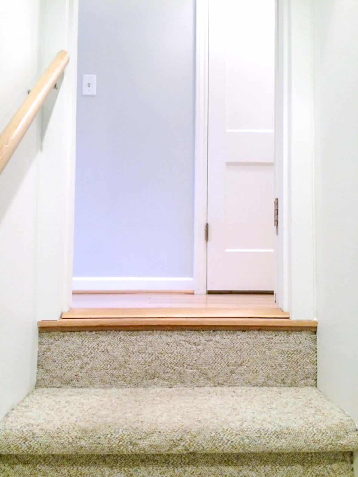 completed basement door trim at top of the stairs