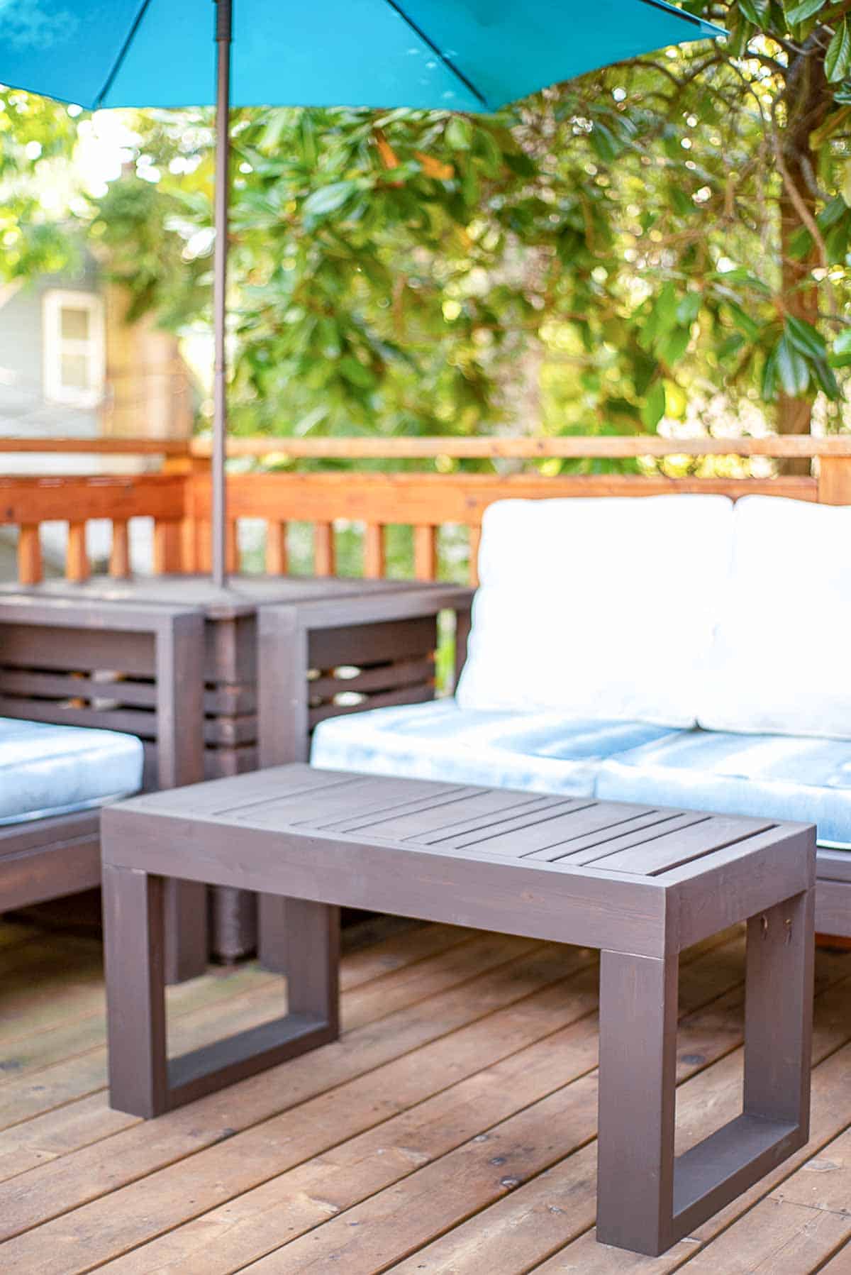 outdoor seating area on deck with DIY outdoor loveseat, sofa, coffee table and umbrella side table
