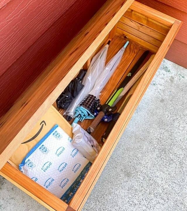 DIY wood outdoor storage box with umbrellas and packages inside
