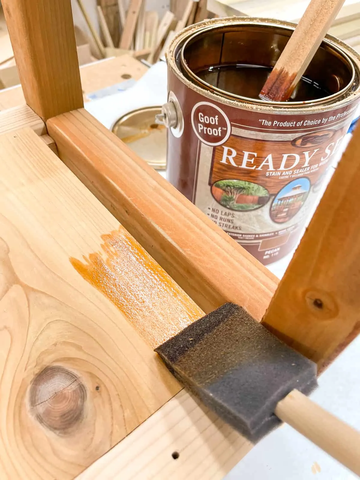 staining the DIY outdoor shelves with Ready Seal in Pecan to match the pressure treated lumber