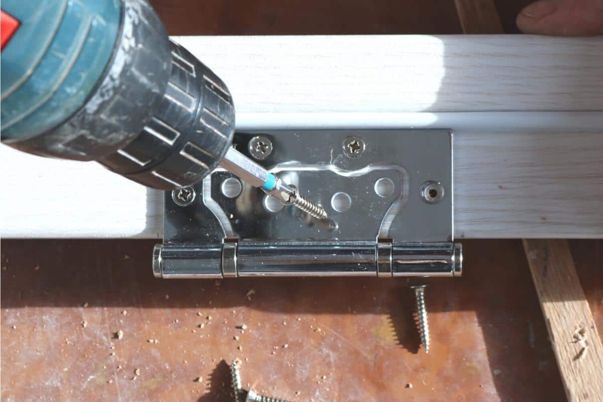 non mortise hinge being installed on a door with a drill