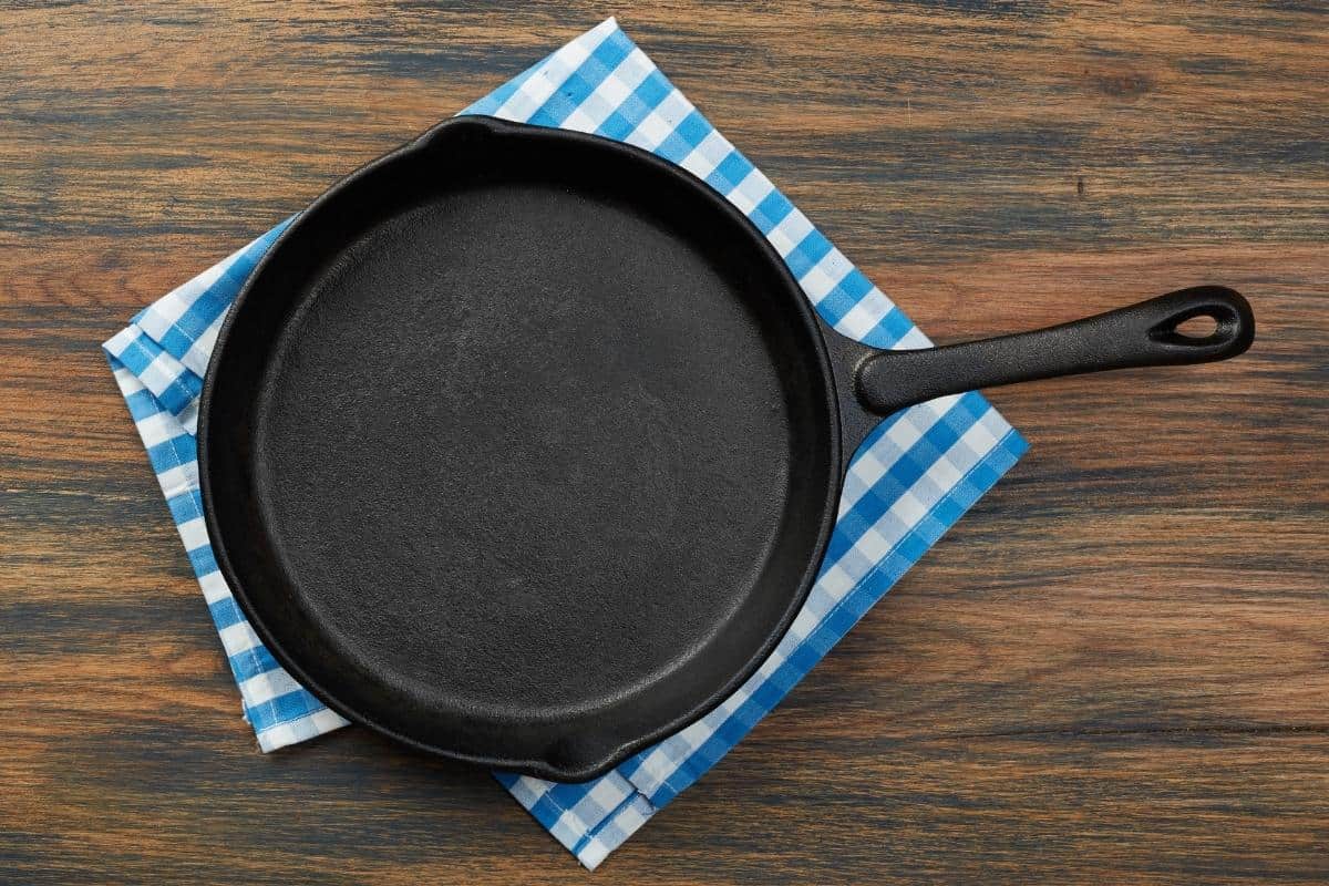 pan on wood countertop with dish towel underneath to protect the surface