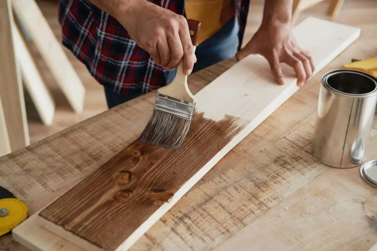 applying wood stain to a board