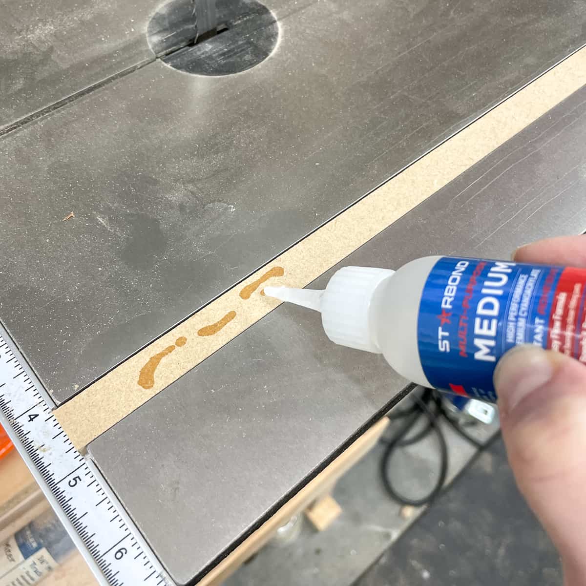 applying CA glue to the bandsaw circle cutting jig runner