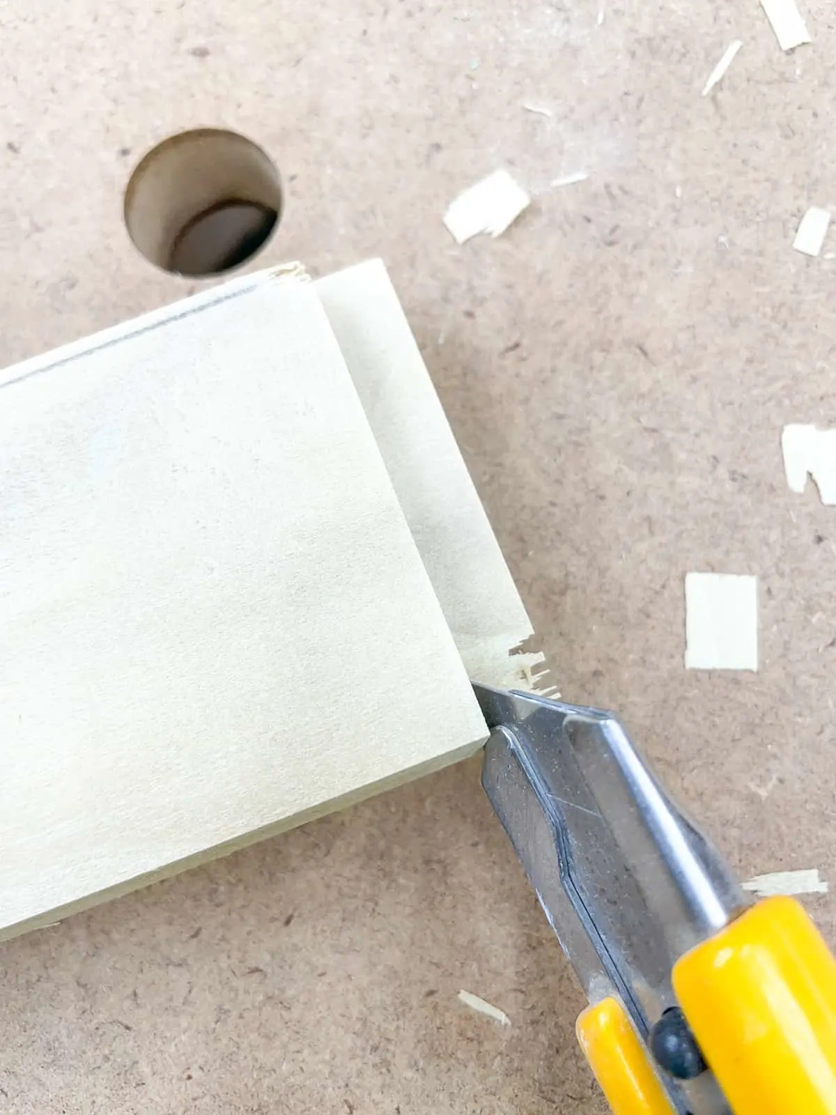 cutting away excess flap of wood on rail piece of cabinet door frame