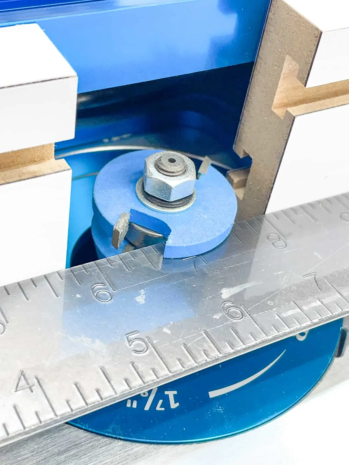 checking the position of the router table fence with a metal ruler