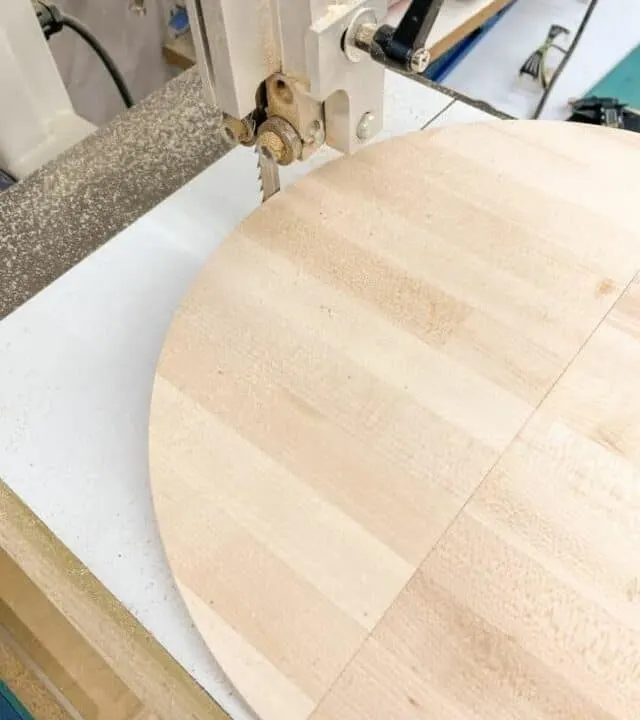 piece of wood being cut into a circle using a band saw circle jig