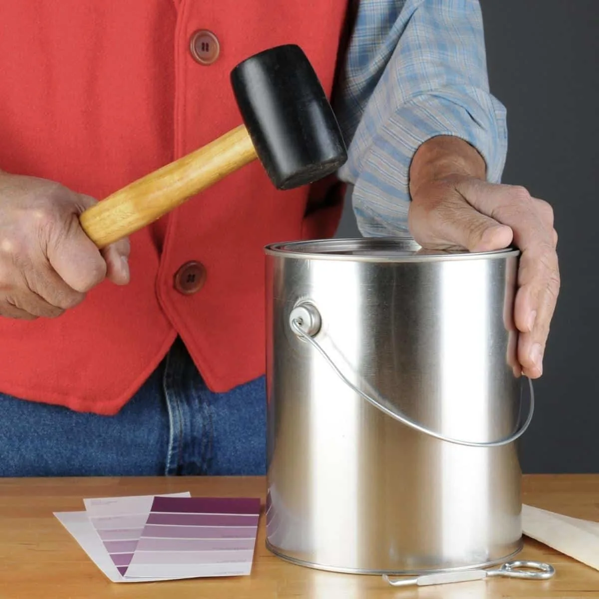 closing a metal paint can with a rubber mallet