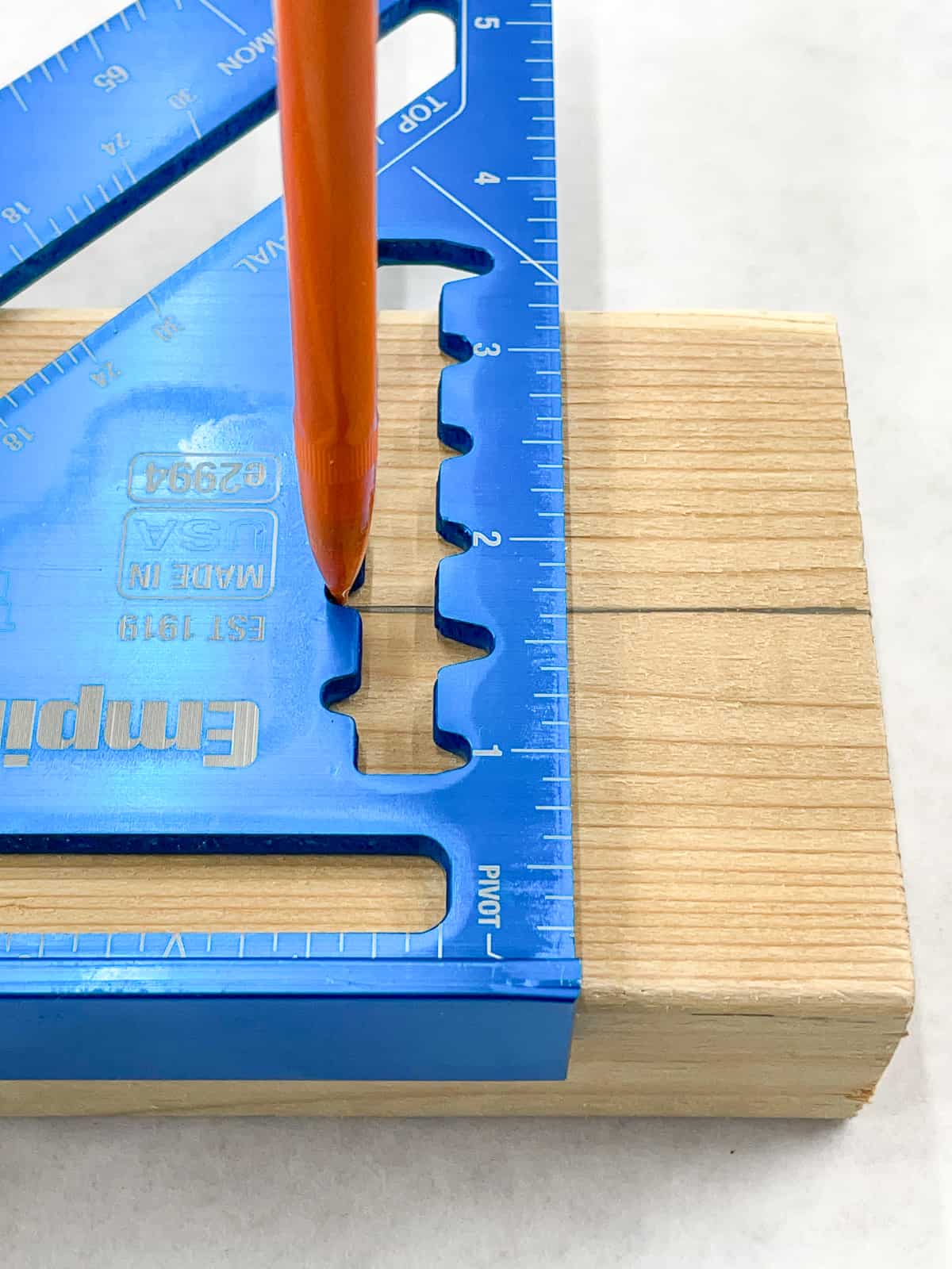 marking a rip cut line down the center of a 2x4 with a speed square