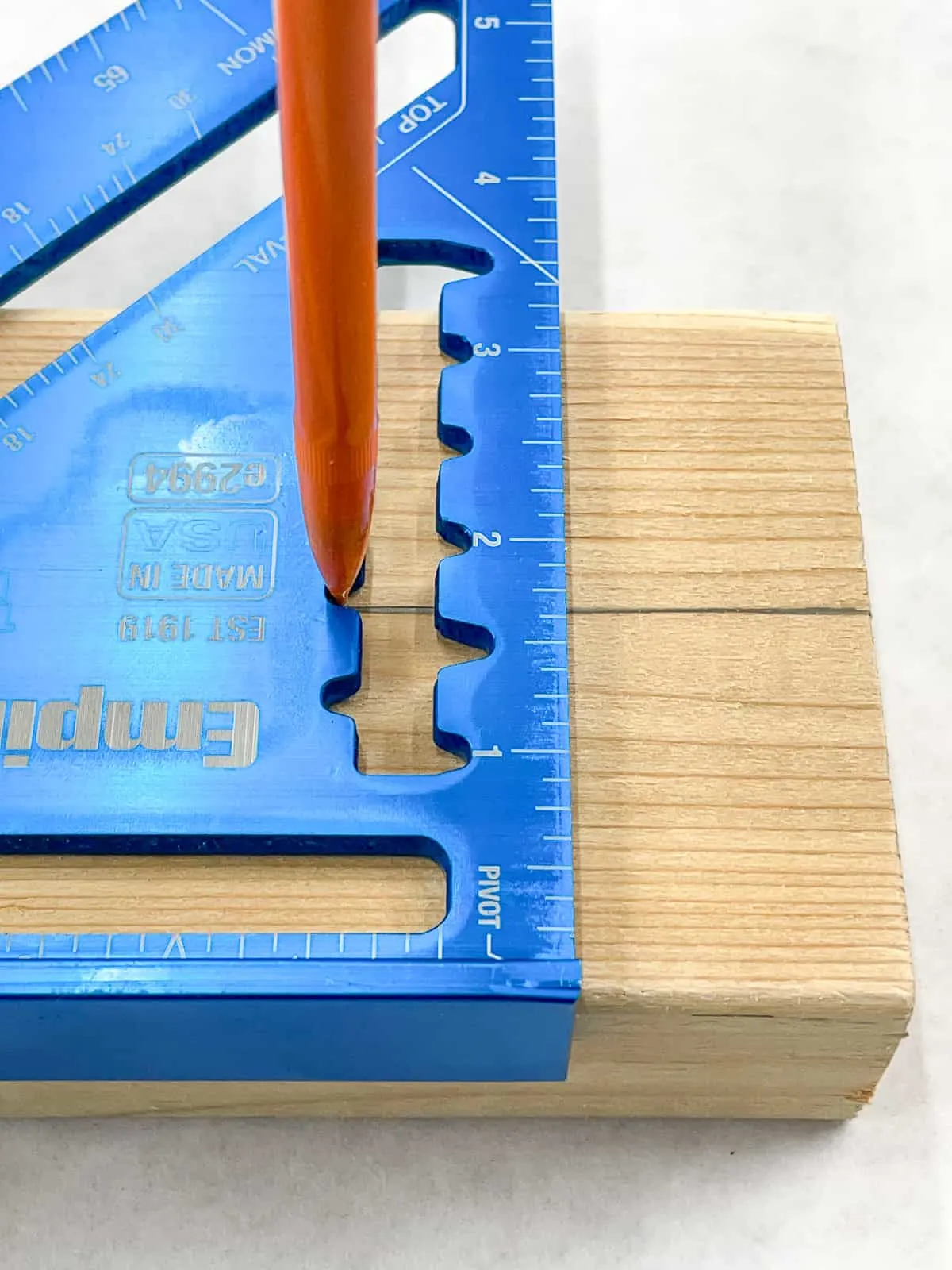 marking a rip cut line down the center of a 2x4 with a speed square