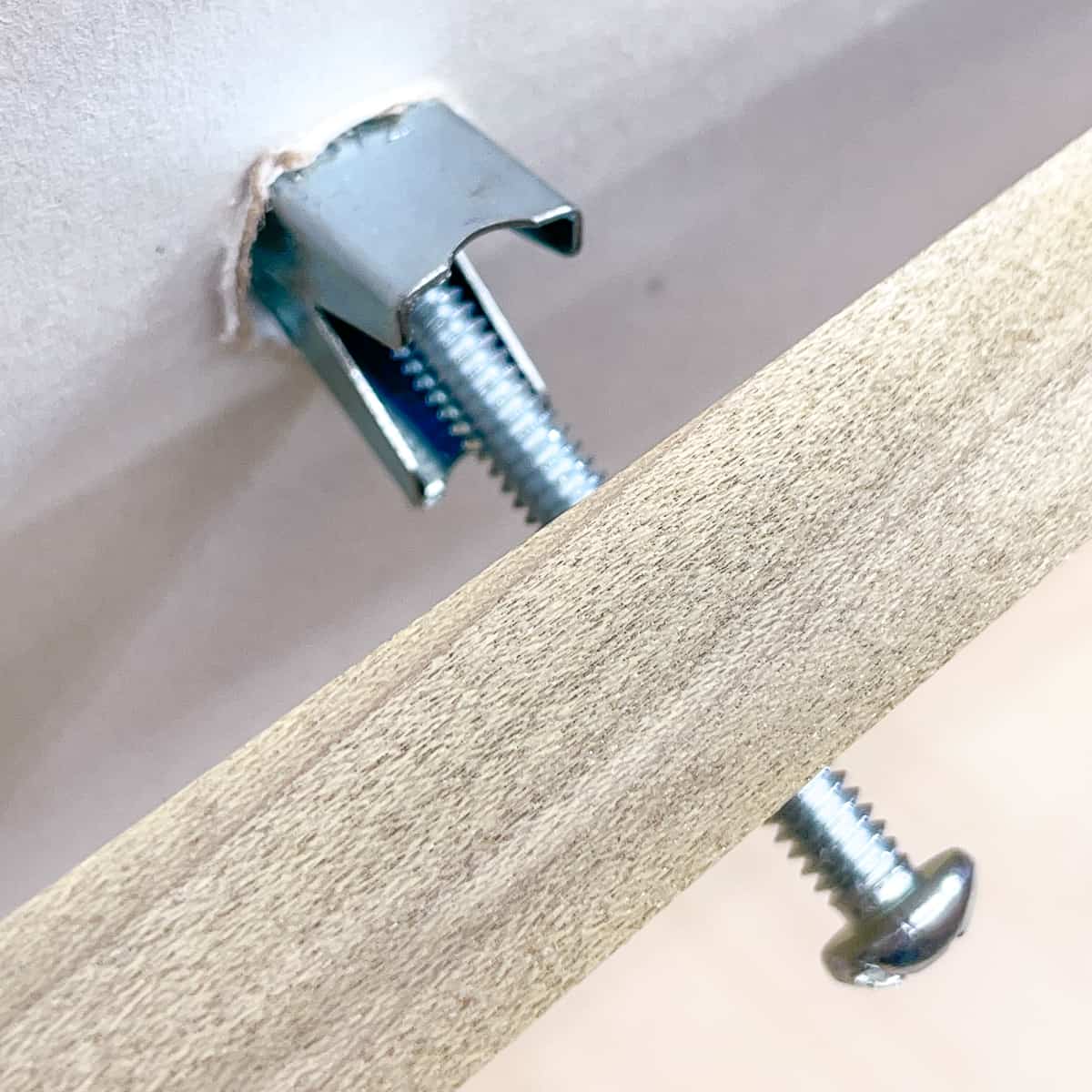 inserting toggle bolt into wall