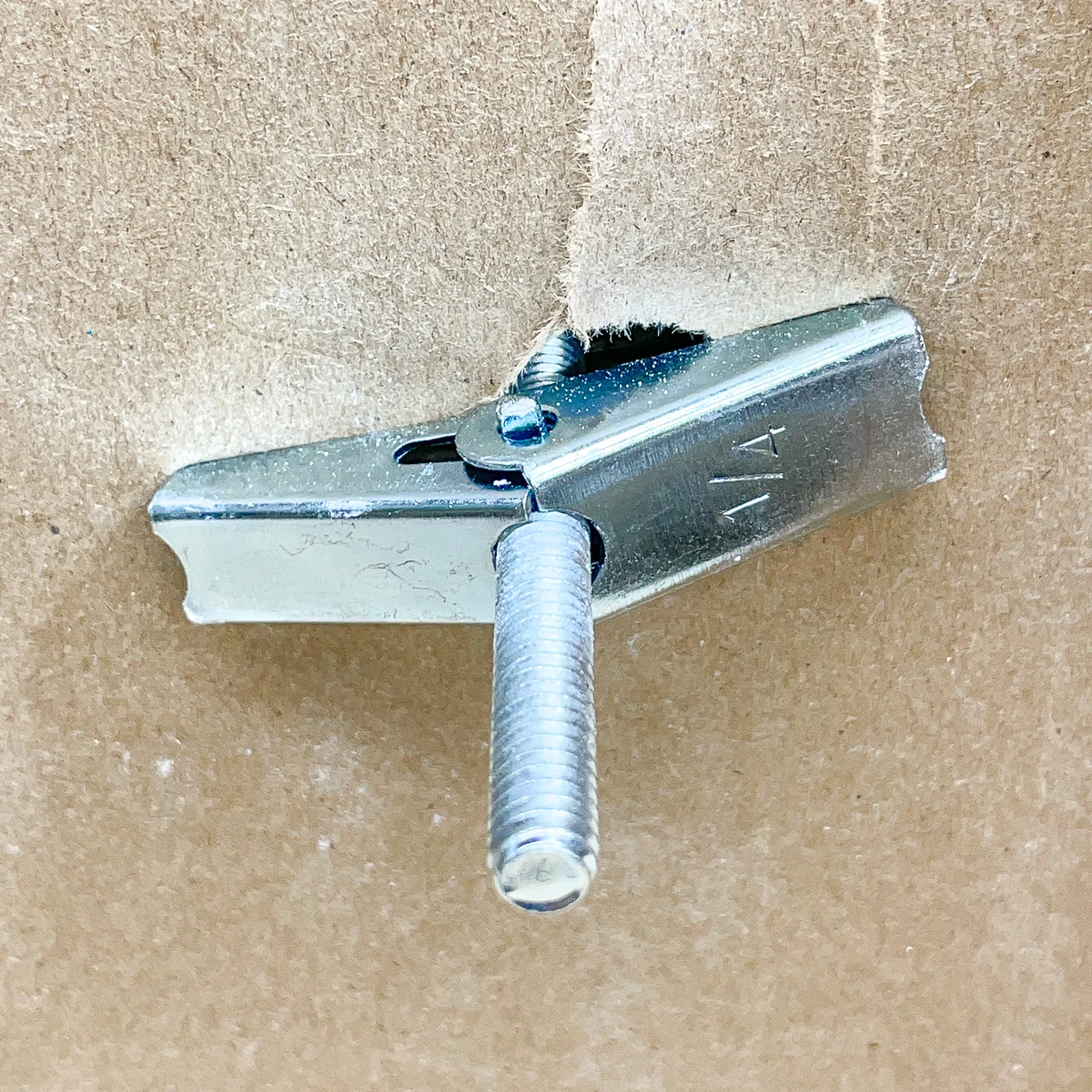 inside the wall, the butterfly nut part of the toggle bolt is tight against the wall when properly installed