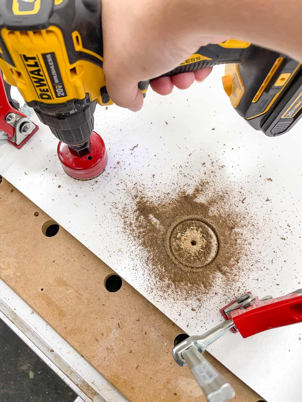 drilling holes for cords and cables in the back of the game console shelves with a hole saw