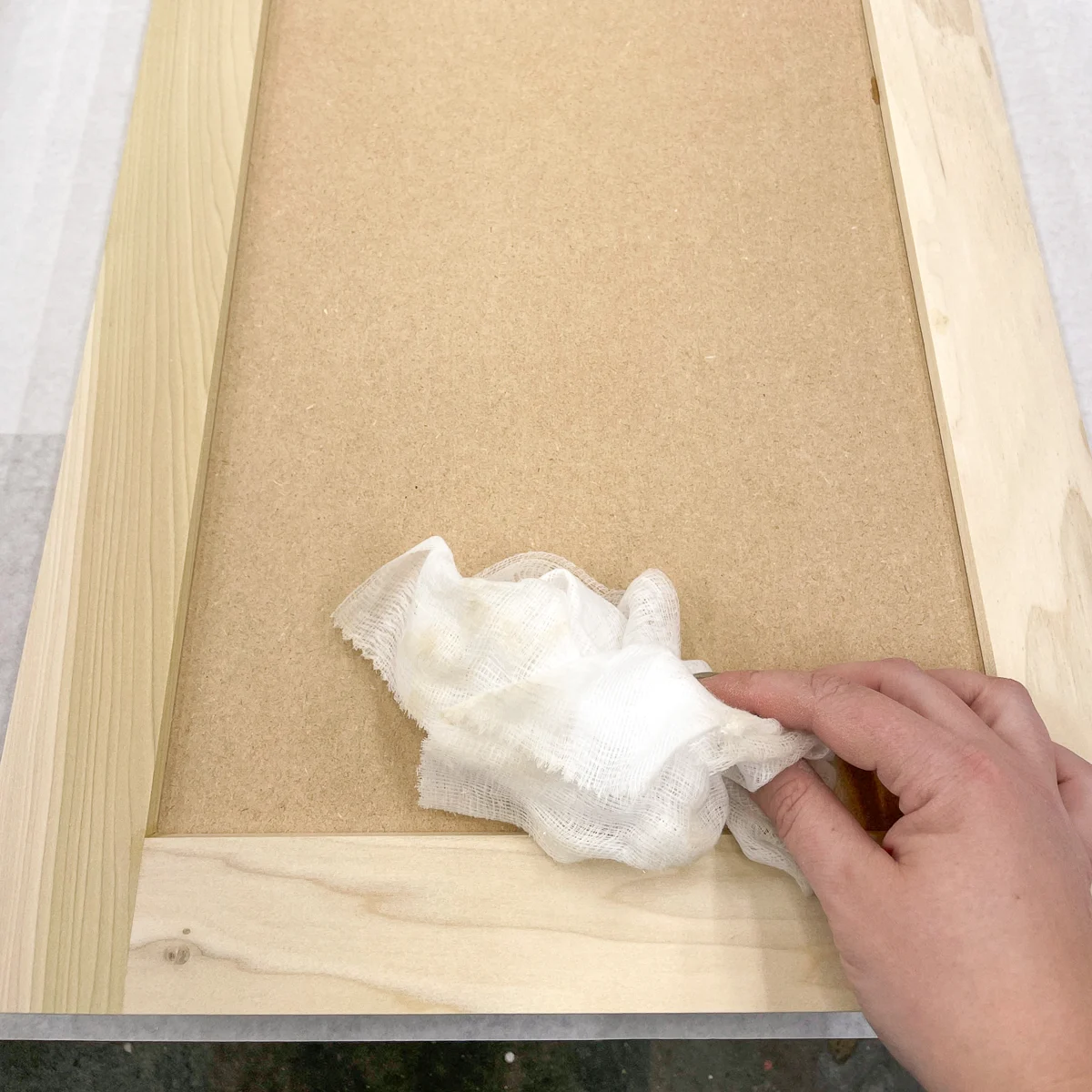 using a tack cloth to remove dust before painting cabinet doors