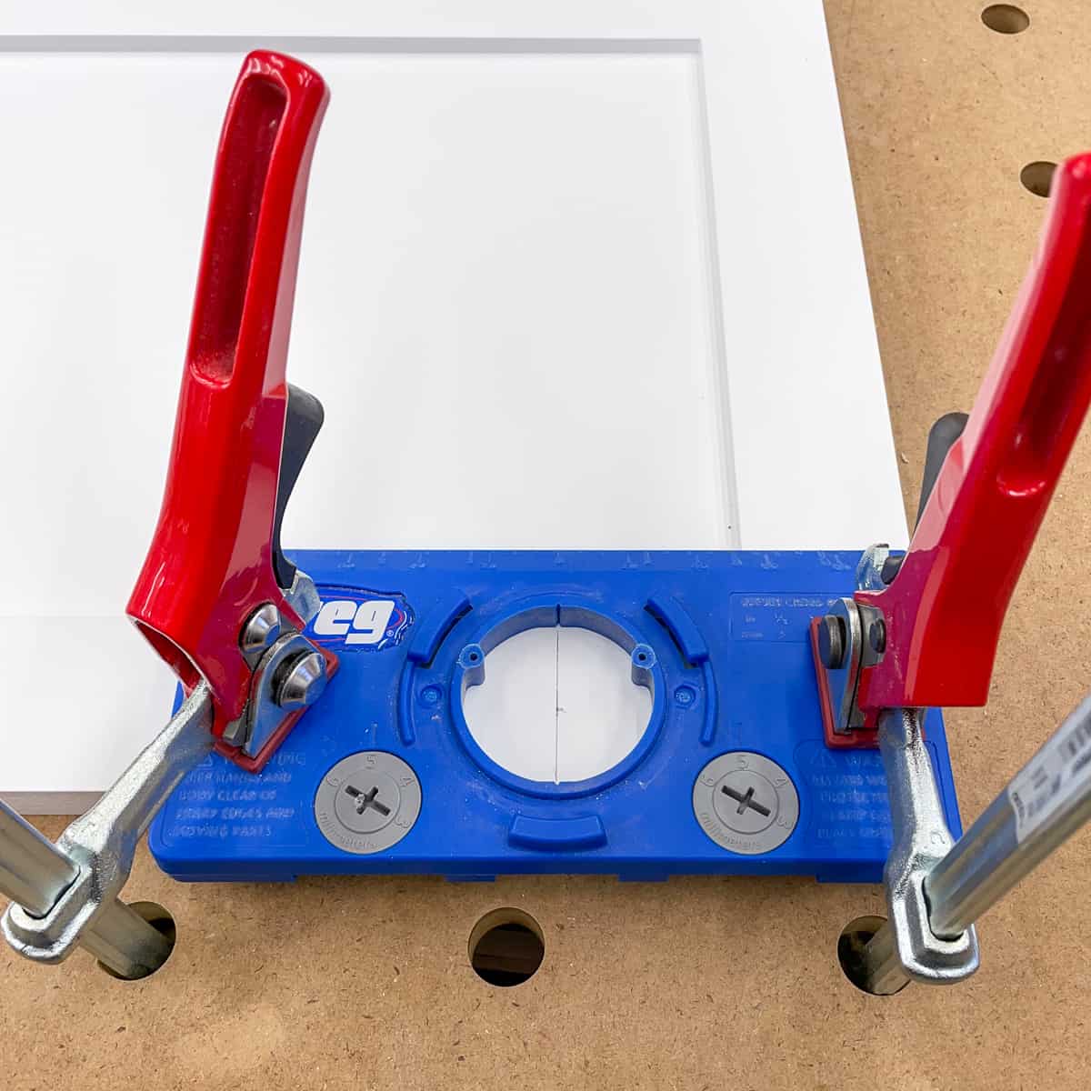 35mm euro hinge drilling jig clamped to cabinet door