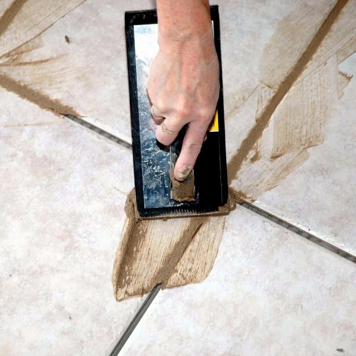 spreading sanded grout with a float